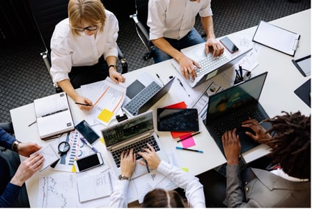 collaborateurs et collaboratrices en réunion sur leurs PC
