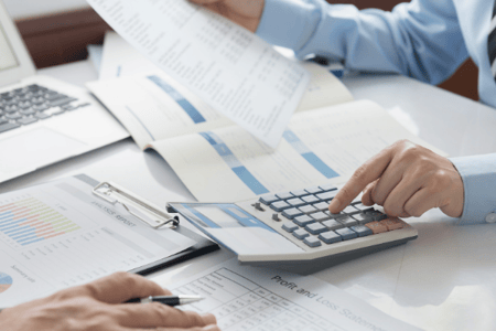 Personne réalisant des calculs et remplissant son tableau de bord