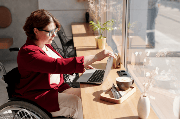 employée en fauteuil roulant entrain de travailler sur son ordinateur