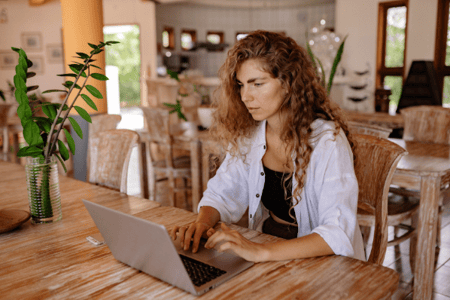 Employée concentrée à son bureau entrain de travailler sur son ordinateur portable