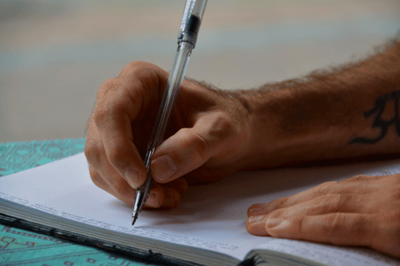 personne écrivant une lettre