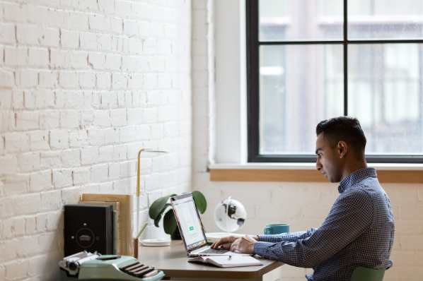 Jeune homme entrain de travailler à son bureau, sur son ordinateur