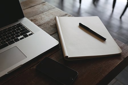 Carnet de notes, téléphone et ordinateur portable