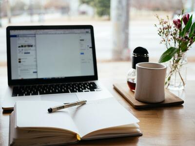 bureau avec bloc note, pc et café