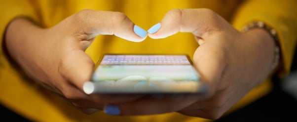 pouces avec vernis à ongle tapant un message sur un smartphone
