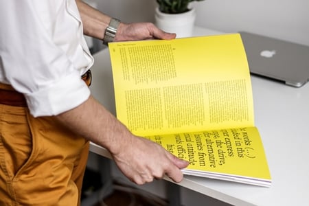homme feuilletant un magasine avec typographie design