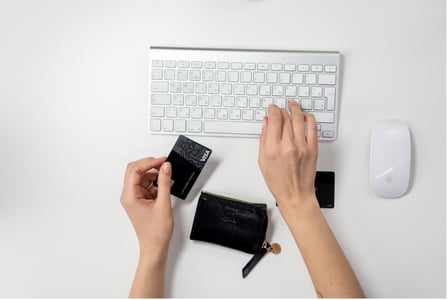 Mains sur un clavier d'ordinateur avec carte bancaire