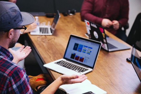 collègues discutant autour d'un ordinateur portable