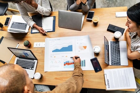 Equipe en réunion entrain d'analyser des graphiques de campagne marketing