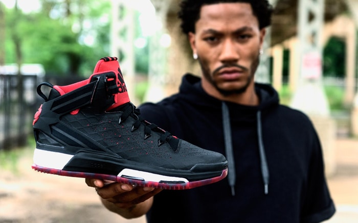 Derrick Rose portant montrant une chaussure Adidas noir et rouge