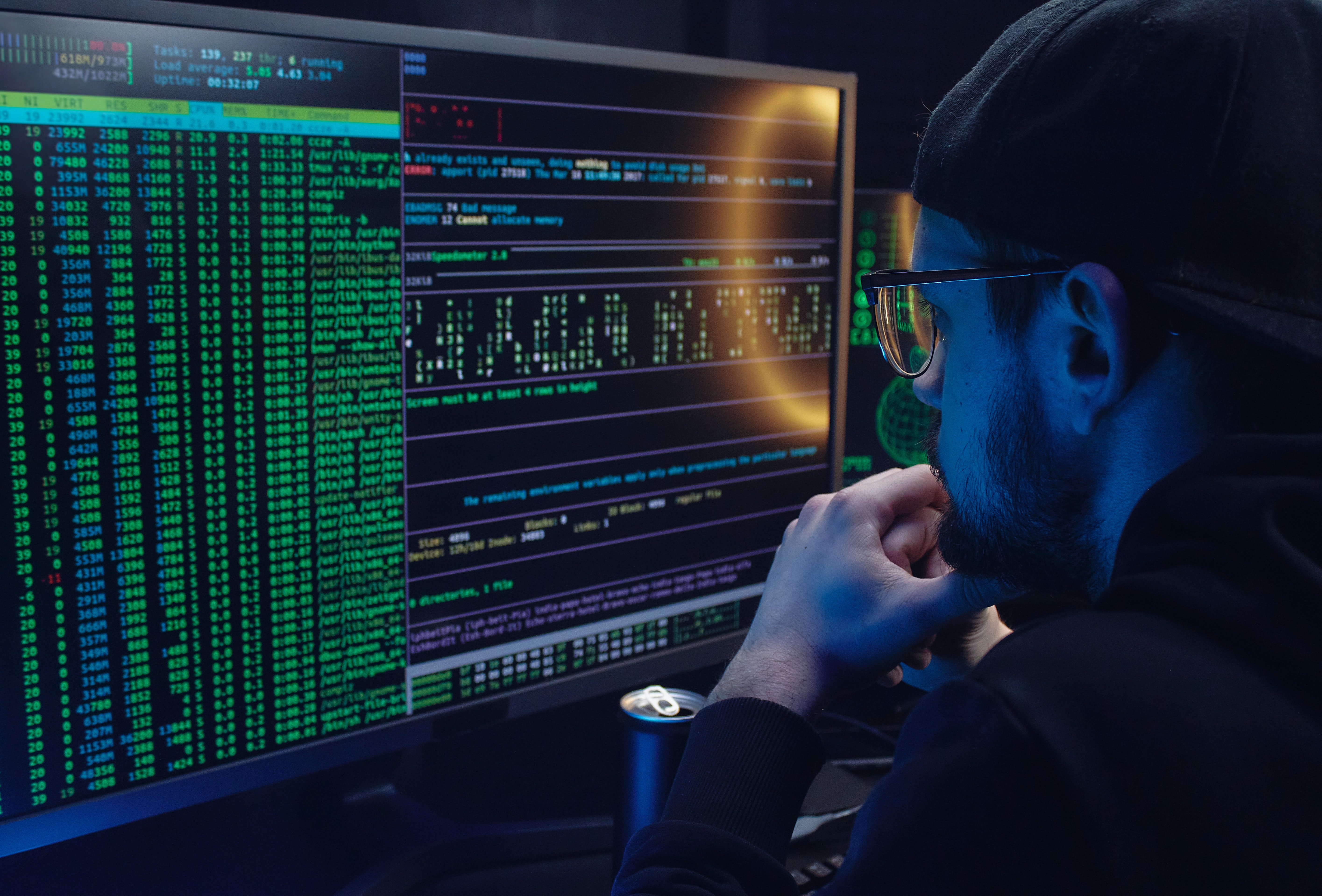 Un cybercriminel devant son ordinateur en train de programmer un maliciel