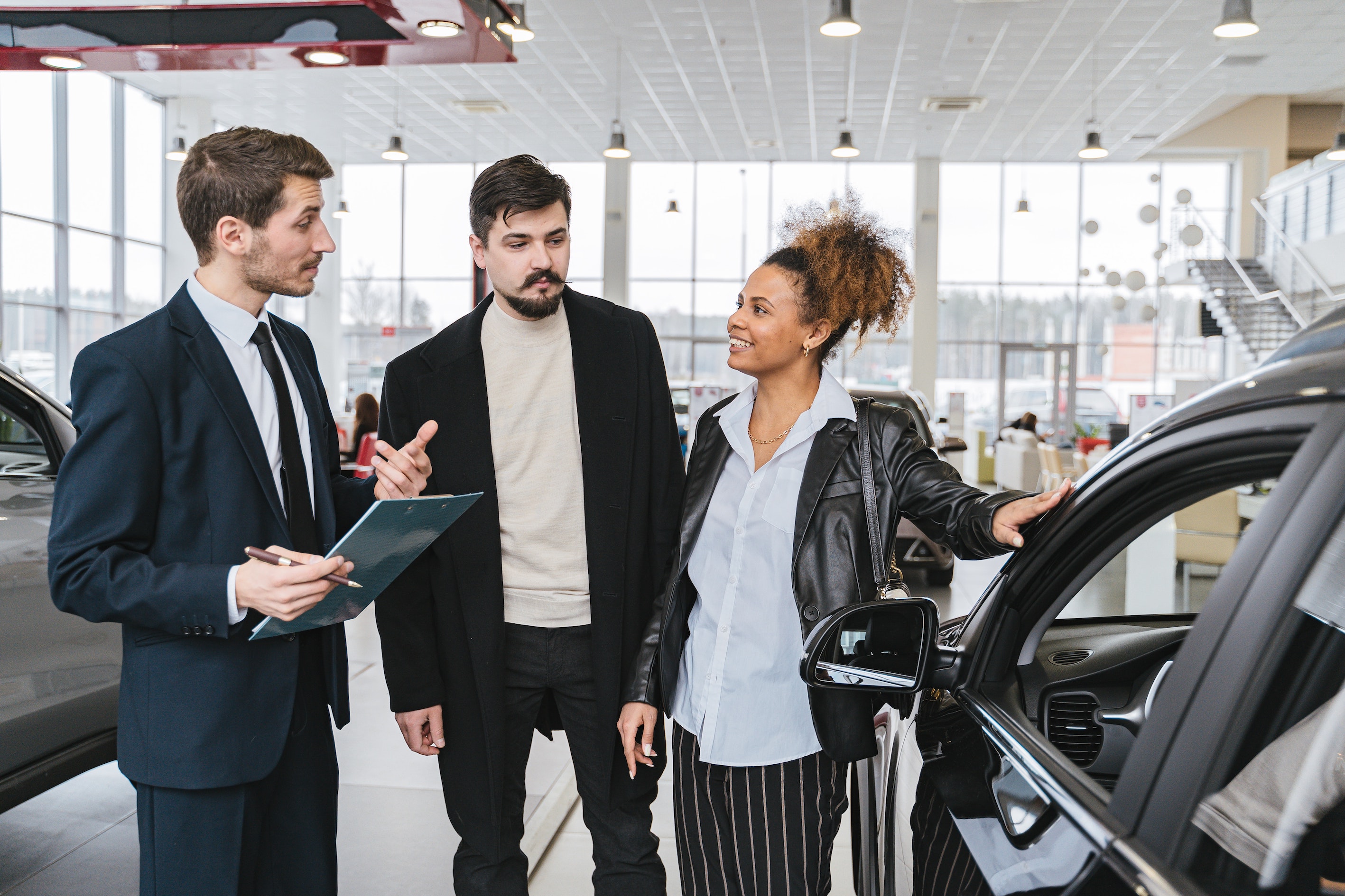 vendeur automobile parlant à un couple de clients potentiels